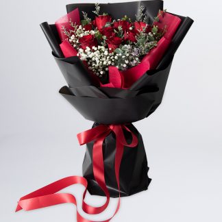 ช่อดอกกุหลาบแดง แซมด้วยดอกยิปซี และดอกแคสเปีย ห่อช่อด้วยกระดาษสาสีแดงด้านใน และกระดาษสีดำด้านนอก
