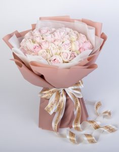 ช่อดอกกุหลาบสีชมพูแอปเปิล 50 ดอก จัดเป็นช่อใหญ่ ผูกริบบิ้นสีขาวและสีทองดูหรูหรา